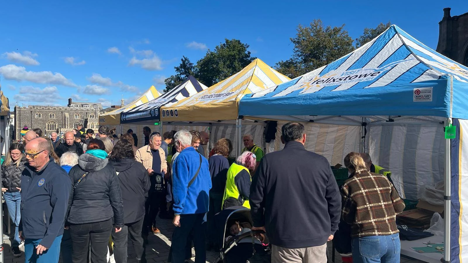 Crowd at striped gazebos during Feed the 5000 on Millennium Plain, Norwich