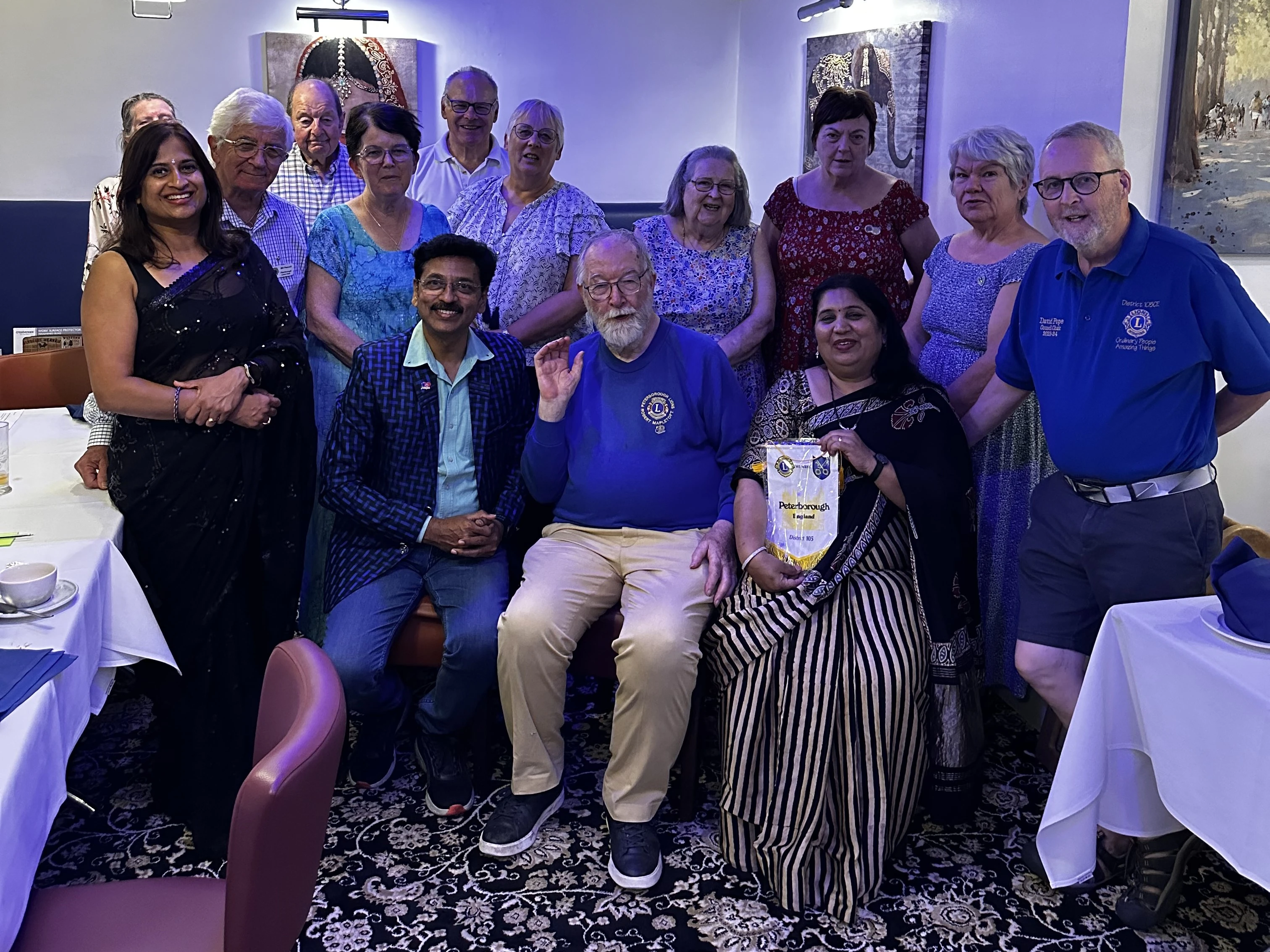 Peterborough Lions with visiting Lions from Ratnagiri and their Longthorpe hosts at Maharani’s Hampton, club pennant in the front row