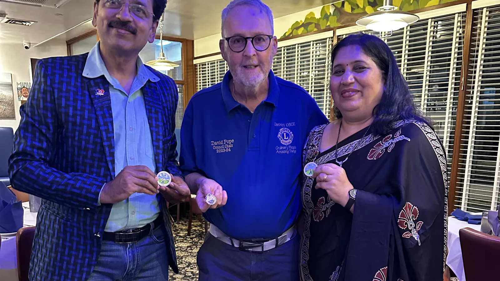 Guests and a Lion holding commemorative pins at Maharani’s Hampton
